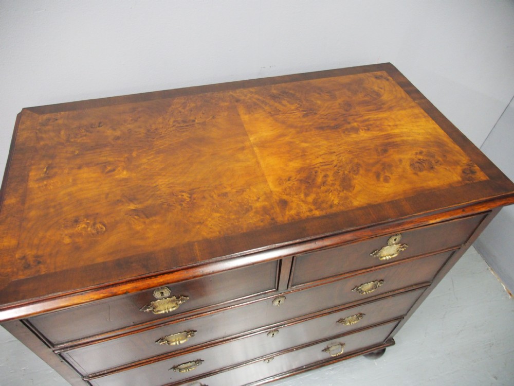 An 18th-century style George III walnut chest of drawers featuring two short over three long drawers with brass handles and escutcheons, set on turned ball feet. View VIII