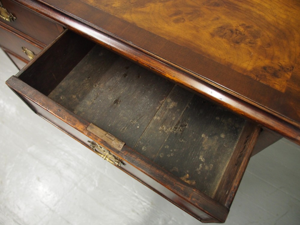 An 18th-century style George III walnut chest of drawers featuring two short over three long drawers with brass handles and escutcheons, set on turned ball feet. View IX