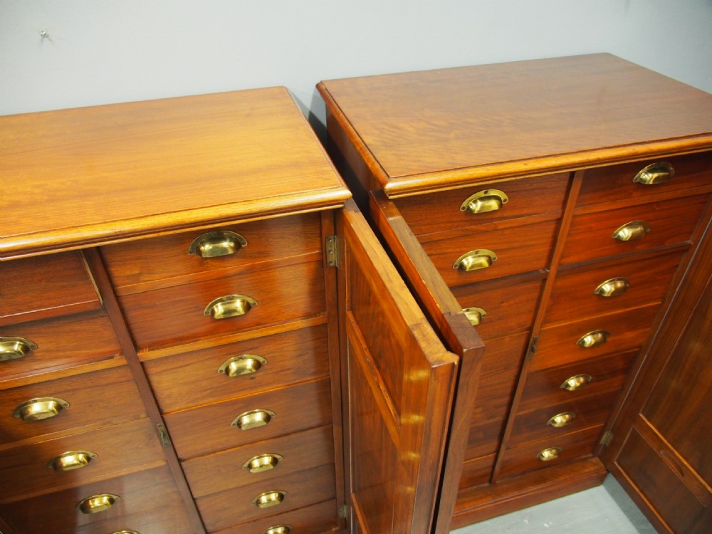 A pair of Victorian warm brown walnut collector cabinets featuring twin doors with decorative burr wood panels and internal fitted shallow drawers with brass cup handles. View V