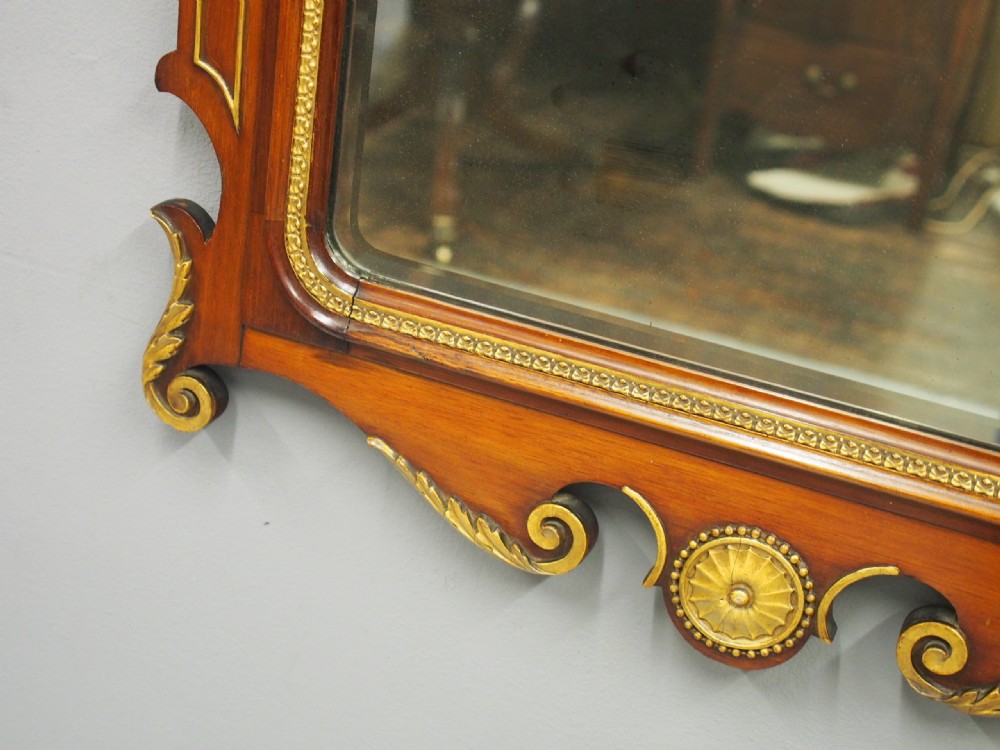 A rectangular George II style wall mirror set in a carved mahogany fretwork frame with gilded accents and a central urn inlay. View VIII
