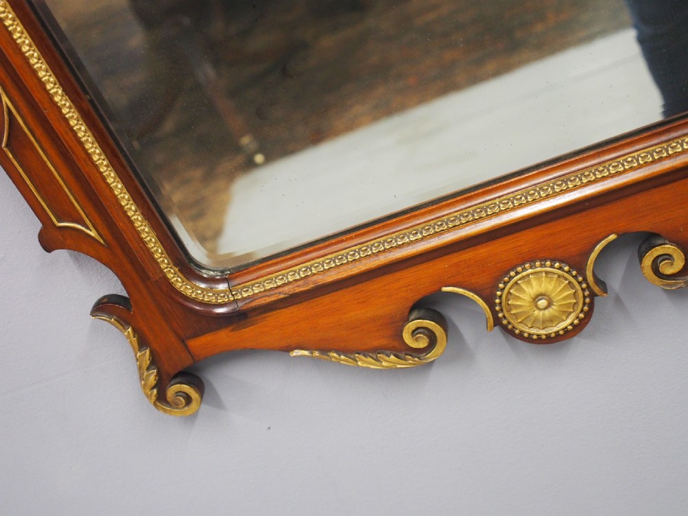 A rectangular George II style wall mirror set in a carved mahogany fretwork frame with gilded accents and a central urn inlay. View IX