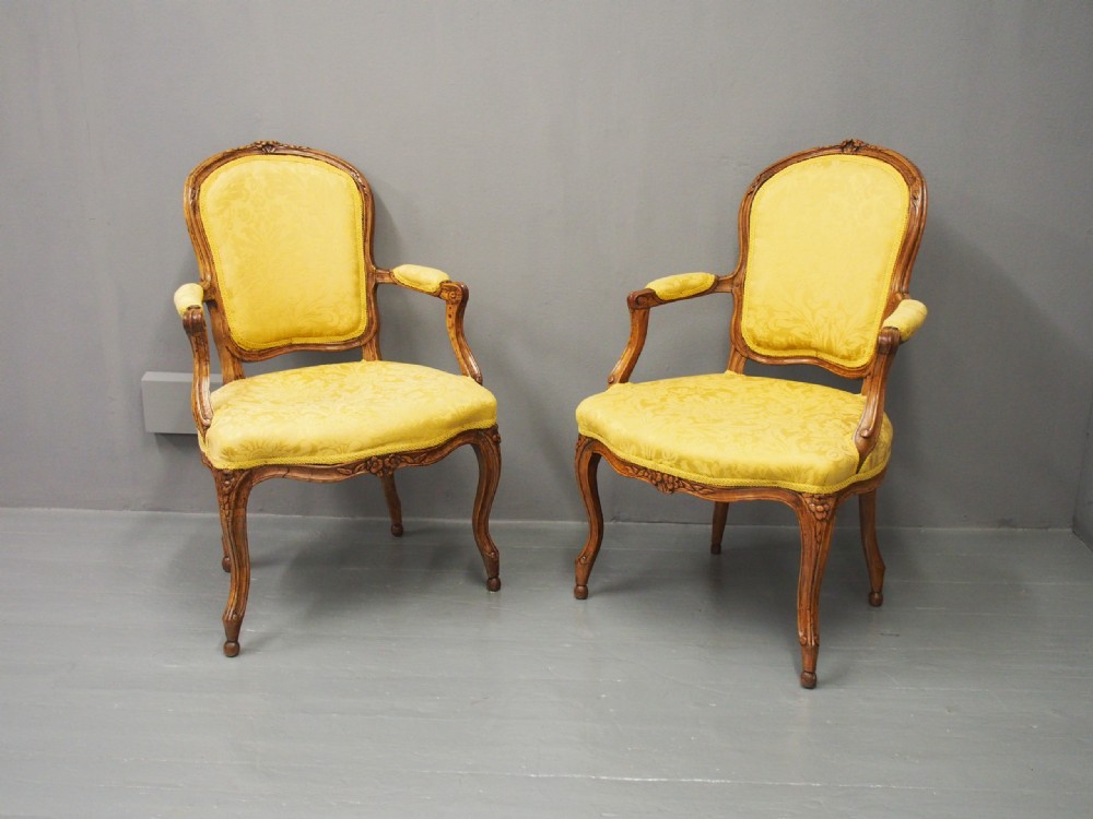 A pair of French Louis XV style armchairs featuring carved wooden frames, cabriole legs, and yellow patterned damask upholstery. View III
