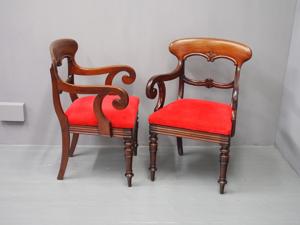 A pair of Victorian mahogany armchairs featuring carved top rails, curved scroll arms, turned front legs, and bright red fabric seat cushions. View XI