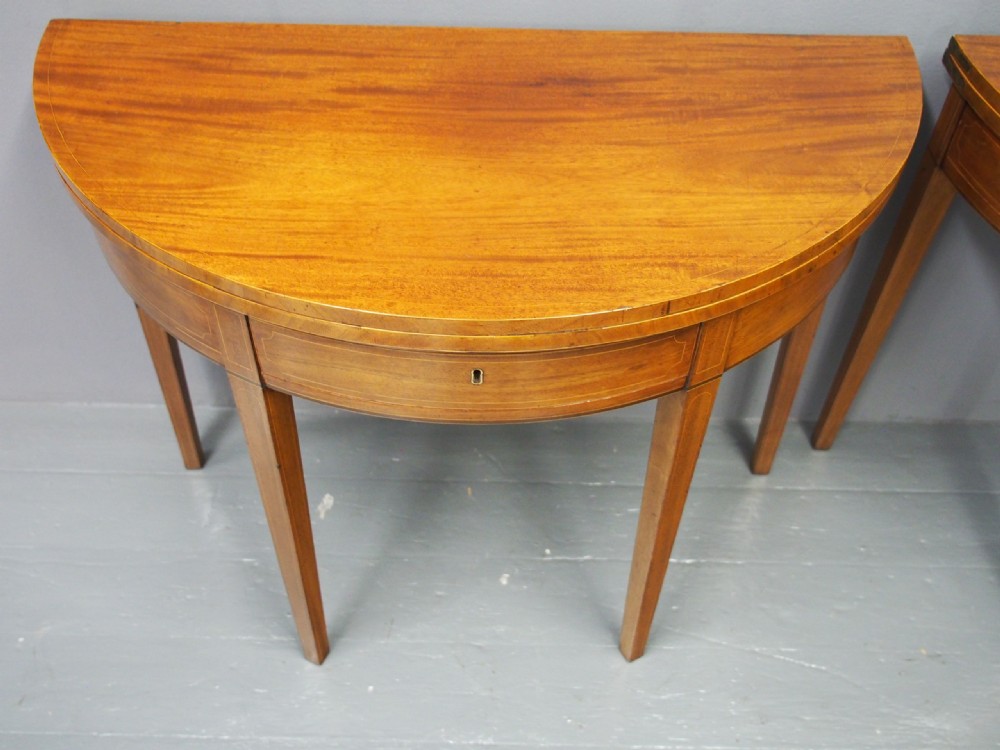 A matching pair of George III demilune mahogany fold-over tea tables with string inlay friezes and square tapered legs. View IV