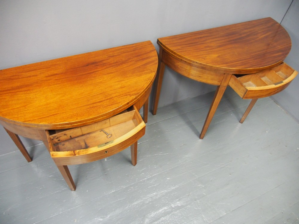 A matching pair of George III demilune mahogany fold-over tea tables with string inlay friezes and square tapered legs. View VI