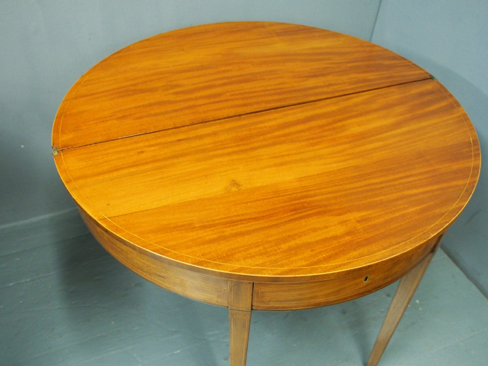 A matching pair of George III demilune mahogany fold-over tea tables with string inlay friezes and square tapered legs. View VIII