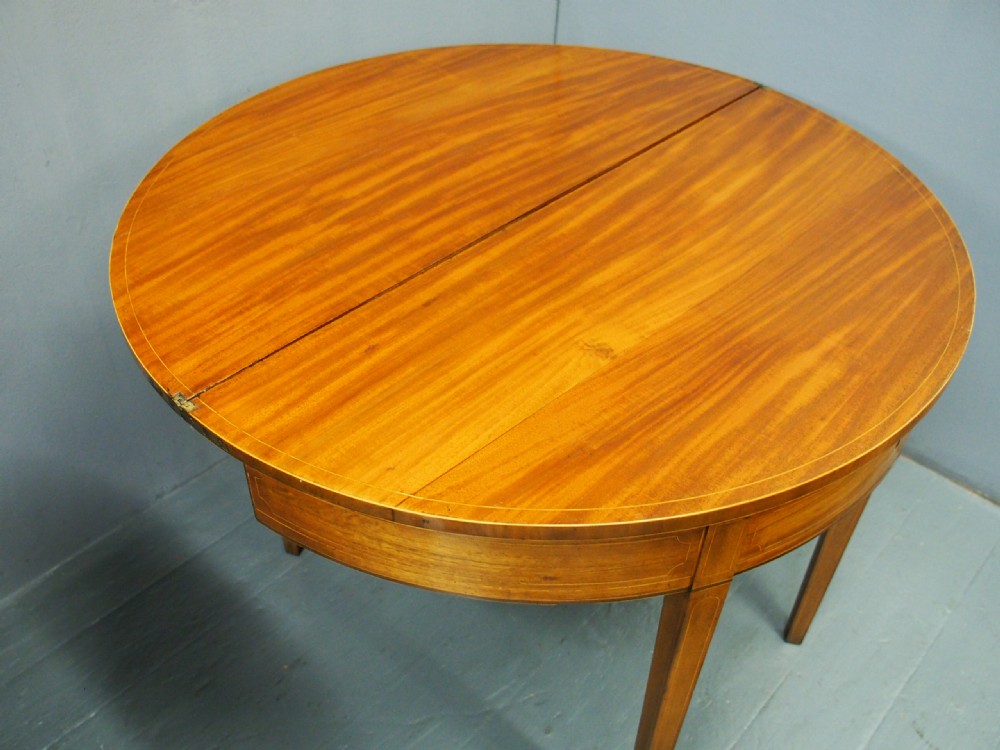 A matching pair of George III demilune mahogany fold-over tea tables with string inlay friezes and square tapered legs. View XI