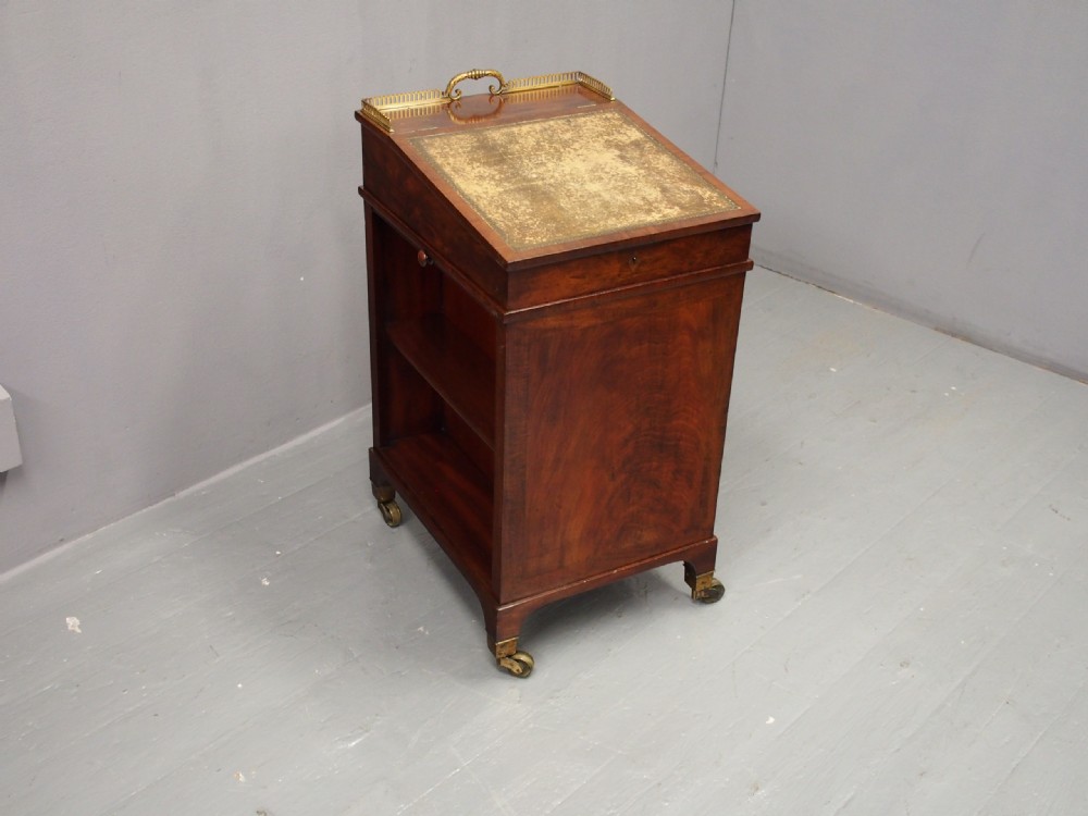 A George IV mahogany Davenport desk with a sloped gold-tooled leather top, upper brass gallery, open side shelving, and brass castors. View III