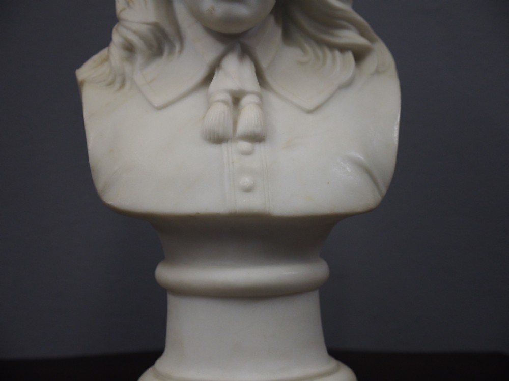A white marble carved portrait bust depicting a gentleman with long flowing hair and period attire mounted on a round socle base. View III