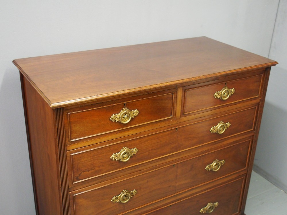 A mahogany chest of drawers in a two short over three long configuration with reeded side columns and cast brass handles. View VI