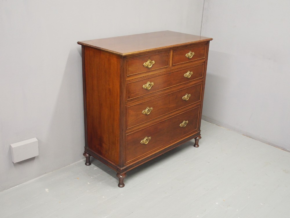A mahogany chest of drawers in a two short over three long configuration with reeded side columns and cast brass handles. View VII
