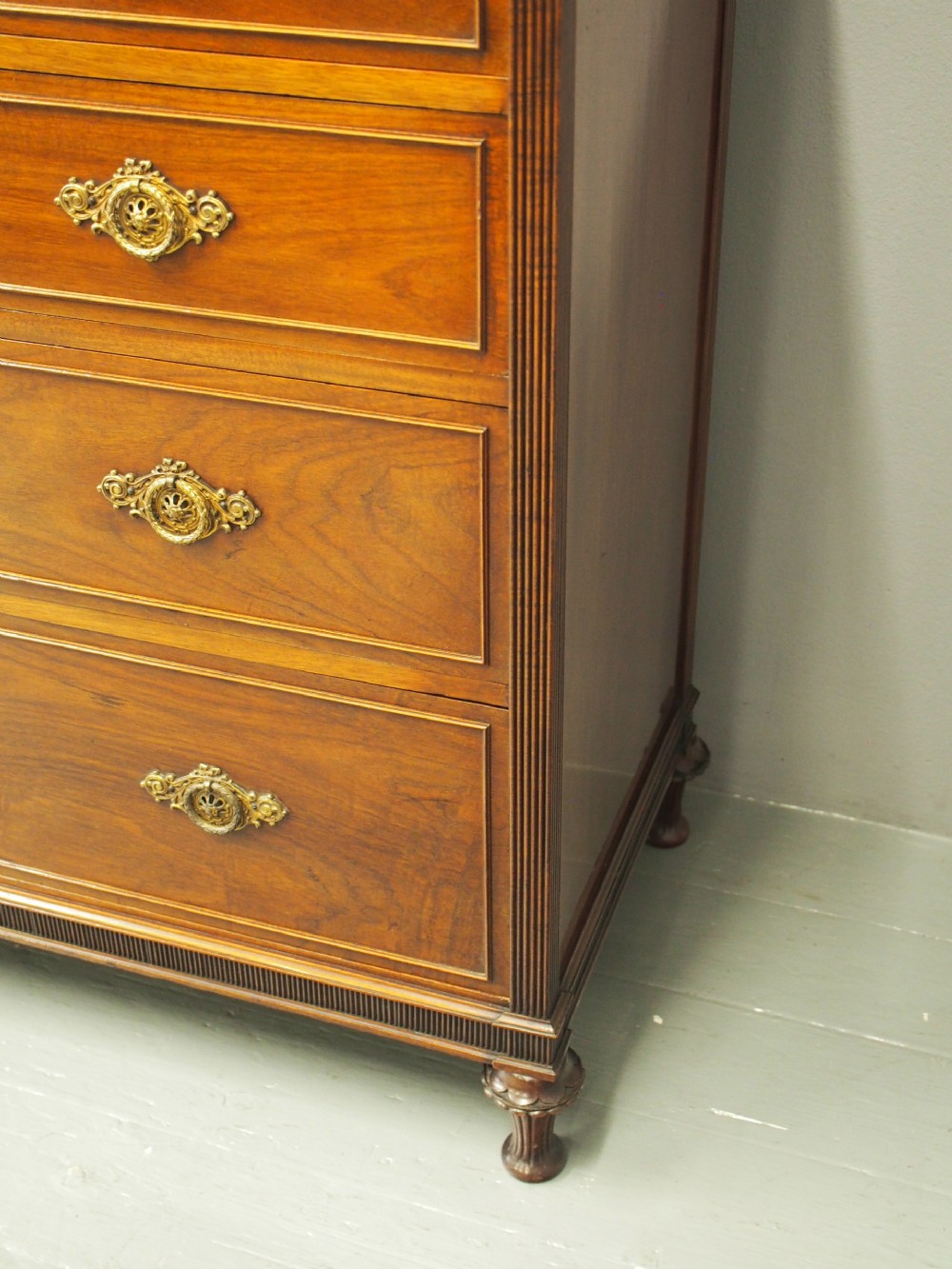 A mahogany chest of drawers in a two short over three long configuration with reeded side columns and cast brass handles. View XI