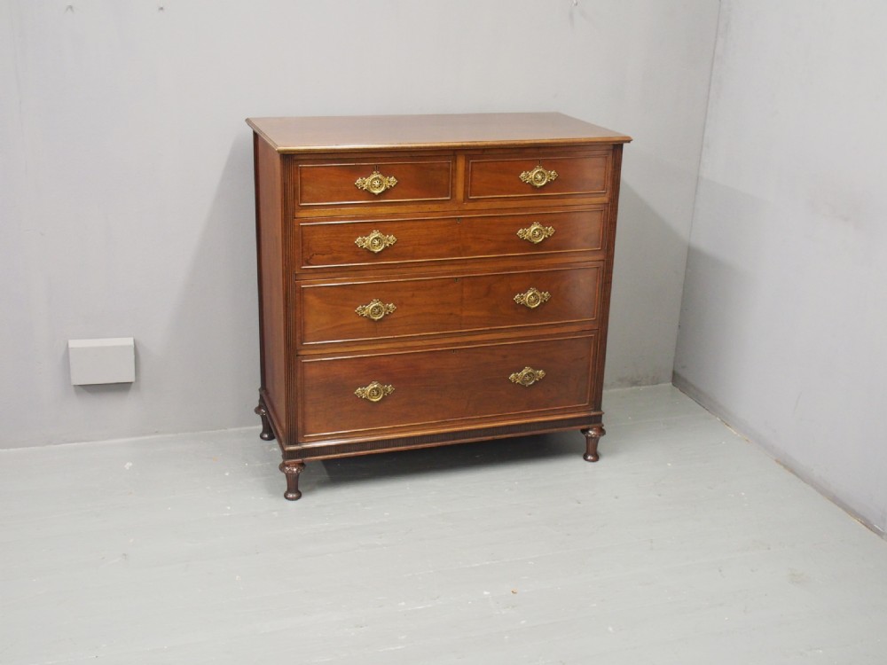 A mahogany chest of drawers in a two short over three long configuration with reeded side columns and cast brass handles. View XIII