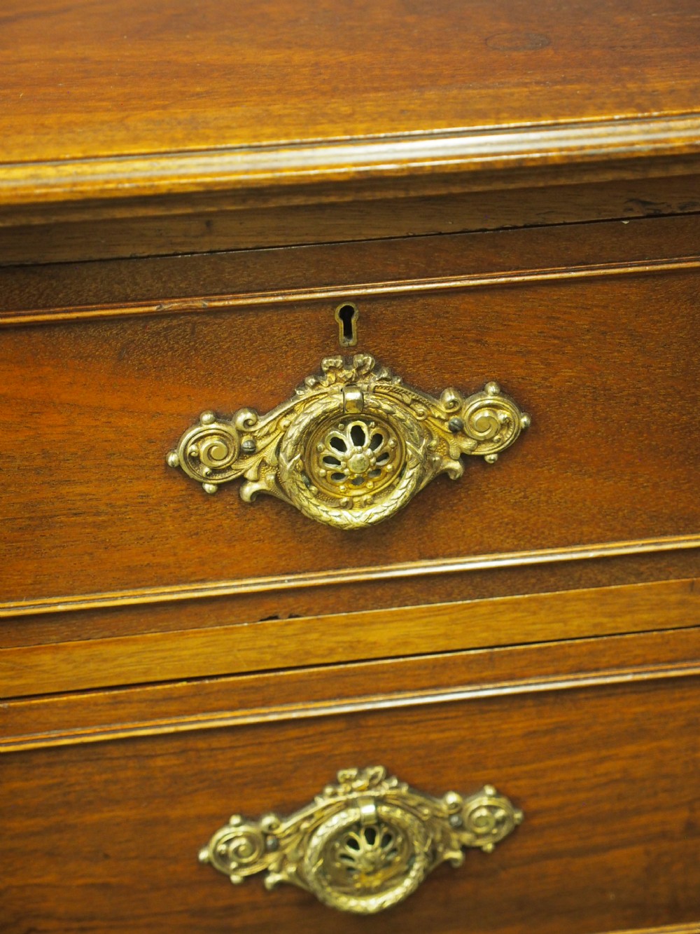 A mahogany chest of drawers in a two short over three long configuration with reeded side columns and cast brass handles. View XIV