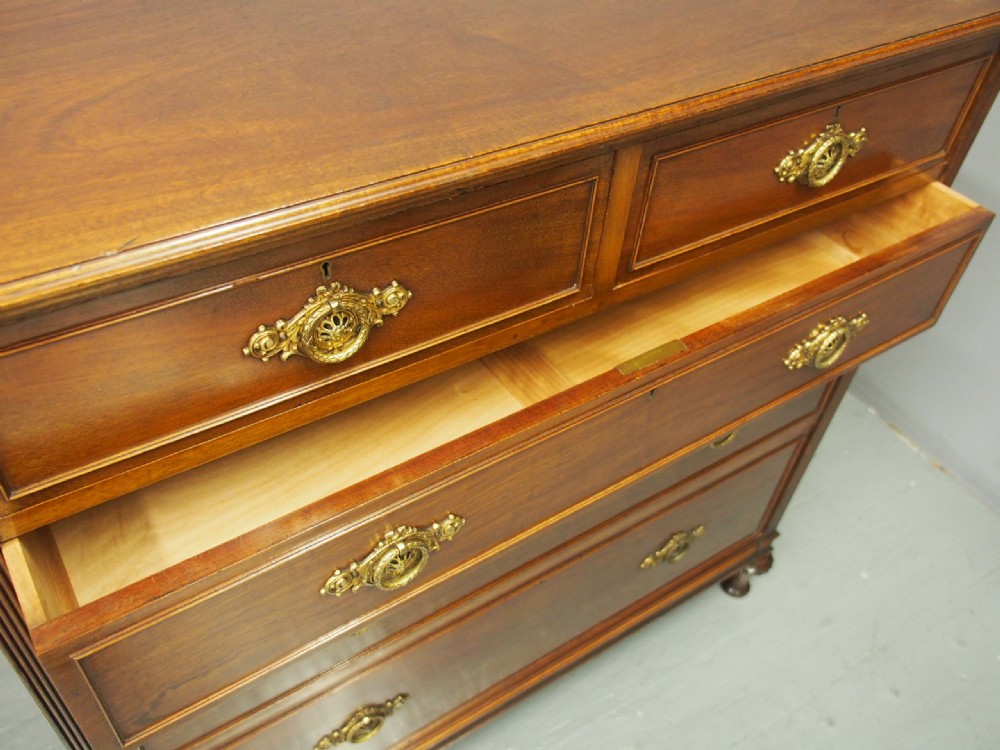 A mahogany chest of drawers in a two short over three long configuration with reeded side columns and cast brass handles. View XV