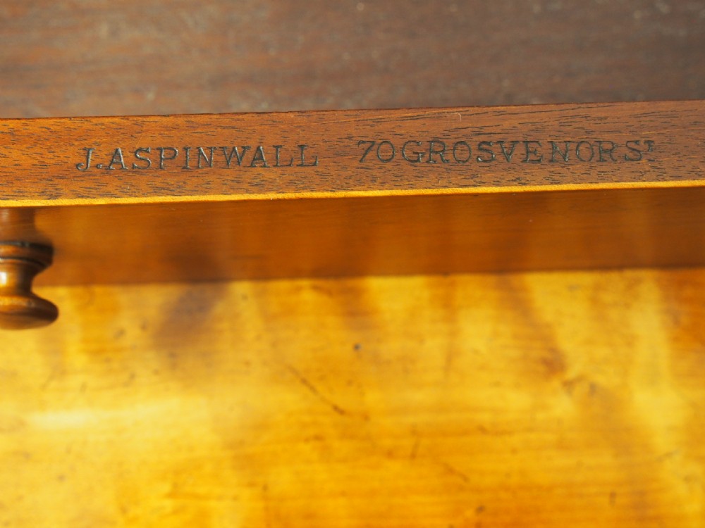 A Victorian satinwood work table featuring a carved top gallery, single drawer, pleated green silk work well, and carved trestle legs. View VI
