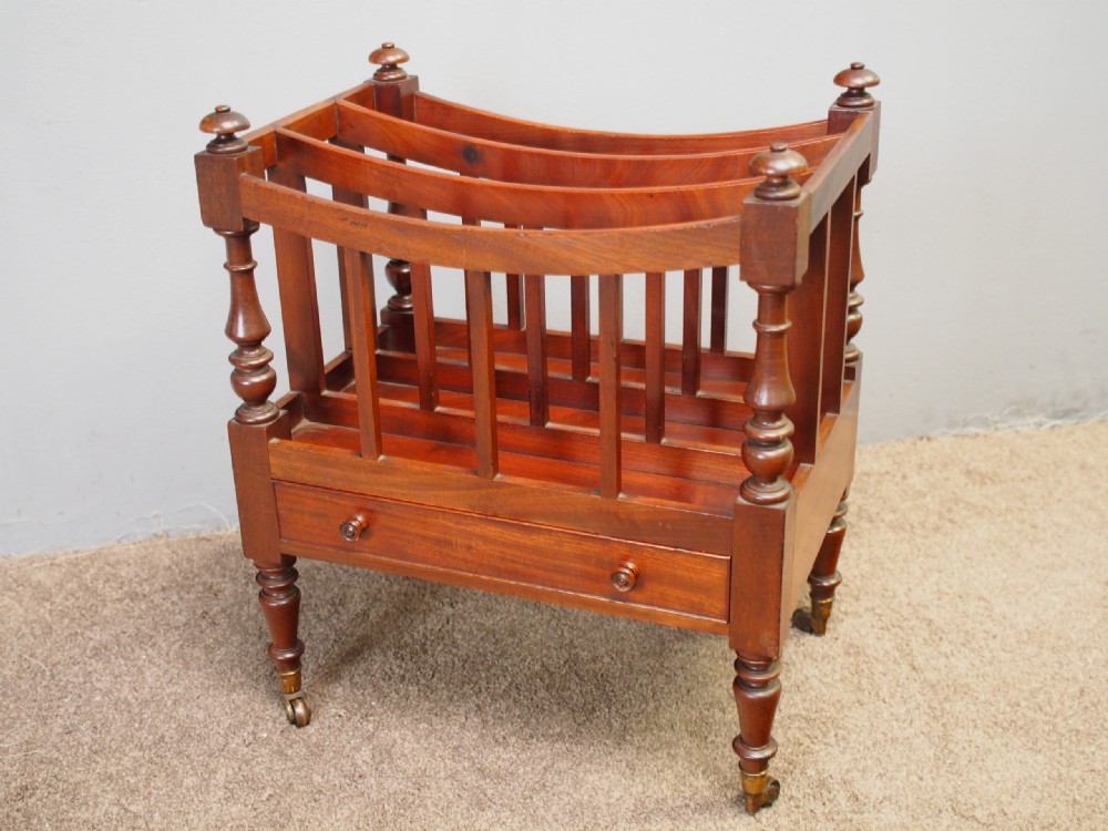 A George IV mahogany three-division Canterbury featuring turned corner posts with finials, slatted partitions, a single base drawer, and turned legs on brass castors. View III