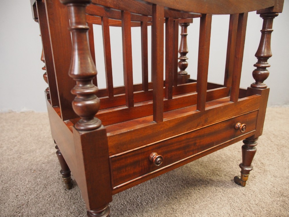 A George IV mahogany three-division Canterbury featuring turned corner posts with finials, slatted partitions, a single base drawer, and turned legs on brass castors. View VII