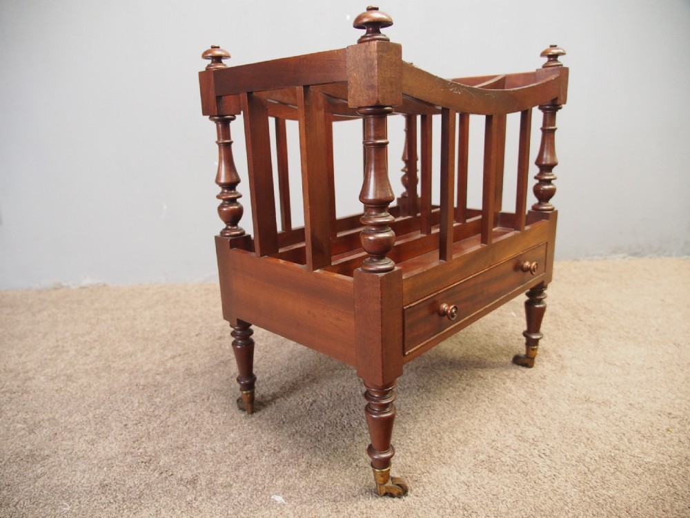 A George IV mahogany three-division Canterbury featuring turned corner posts with finials, slatted partitions, a single base drawer, and turned legs on brass castors. View VIII