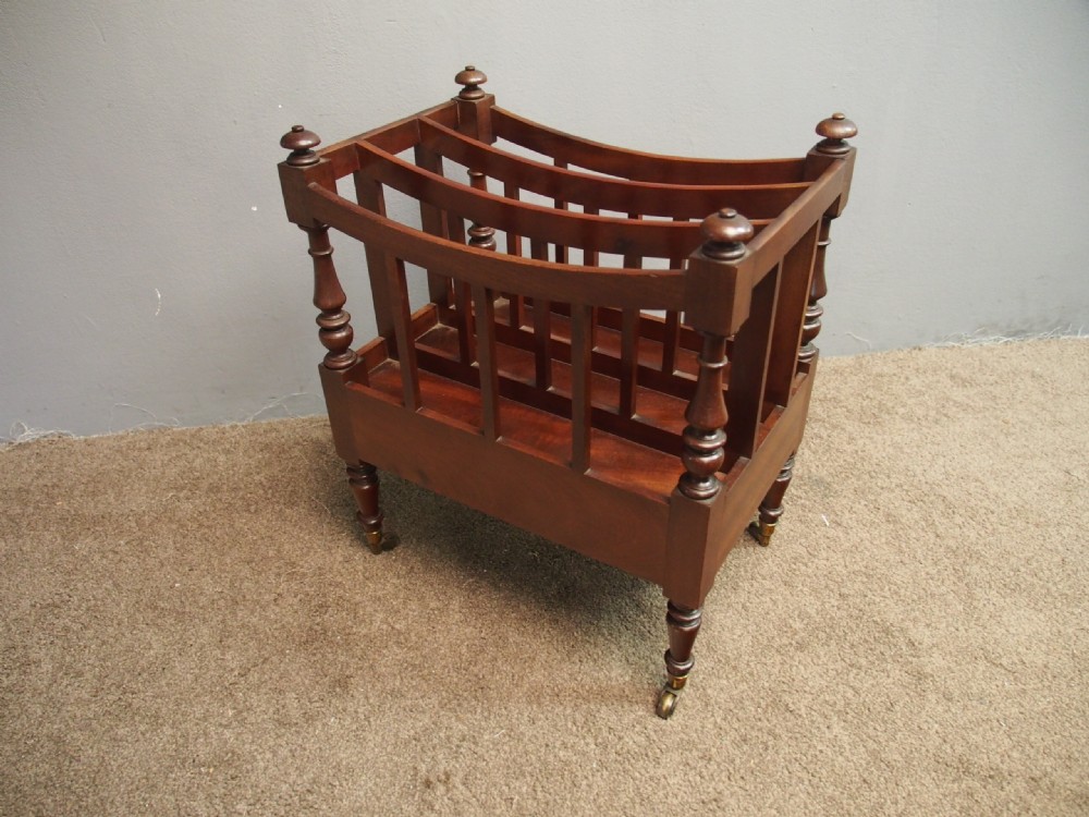 A George IV mahogany three-division Canterbury featuring turned corner posts with finials, slatted partitions, a single base drawer, and turned legs on brass castors. View X