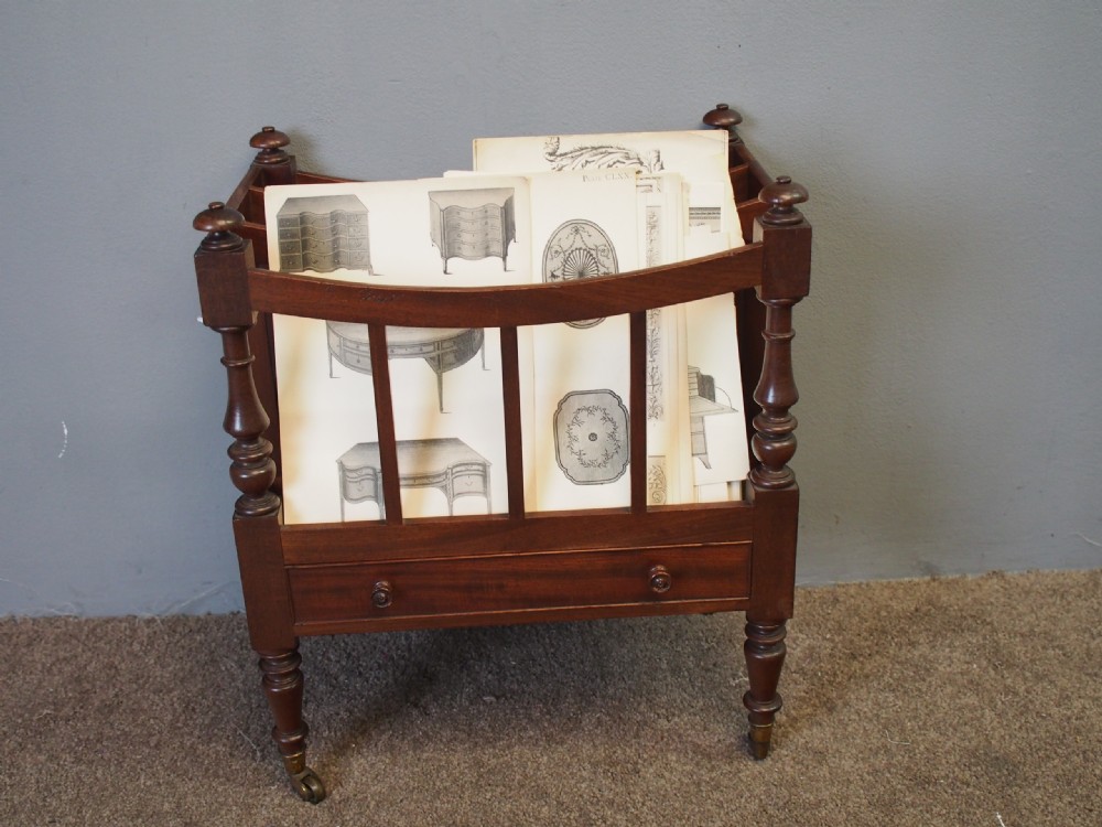 A George IV mahogany three-division Canterbury featuring turned corner posts with finials, slatted partitions, a single base drawer, and turned legs on brass castors. View XI