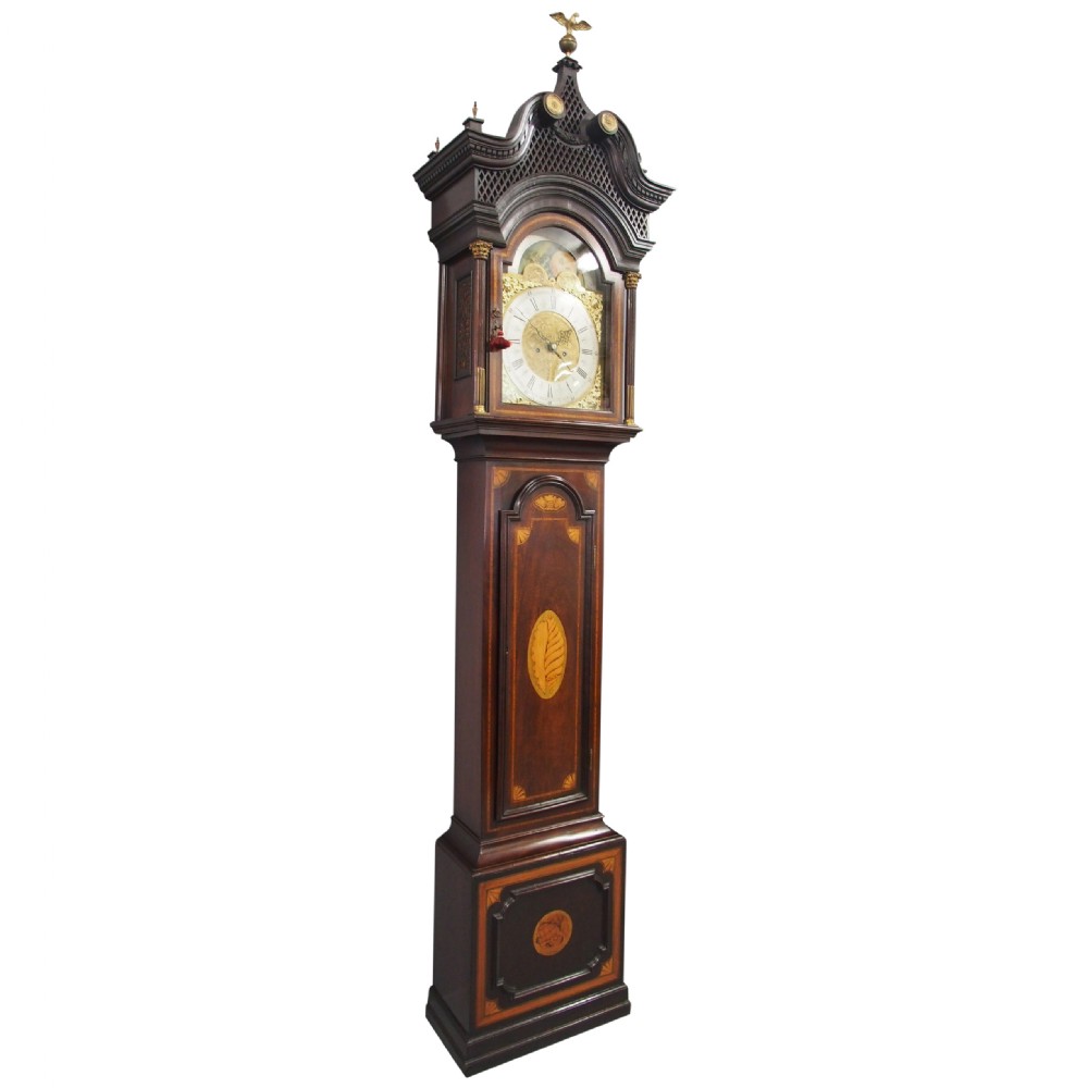 A tall Victorian mahogany longcase clock featuring a swan-neck pediment with fretwork, marquetry inlay, and a brass dial face.