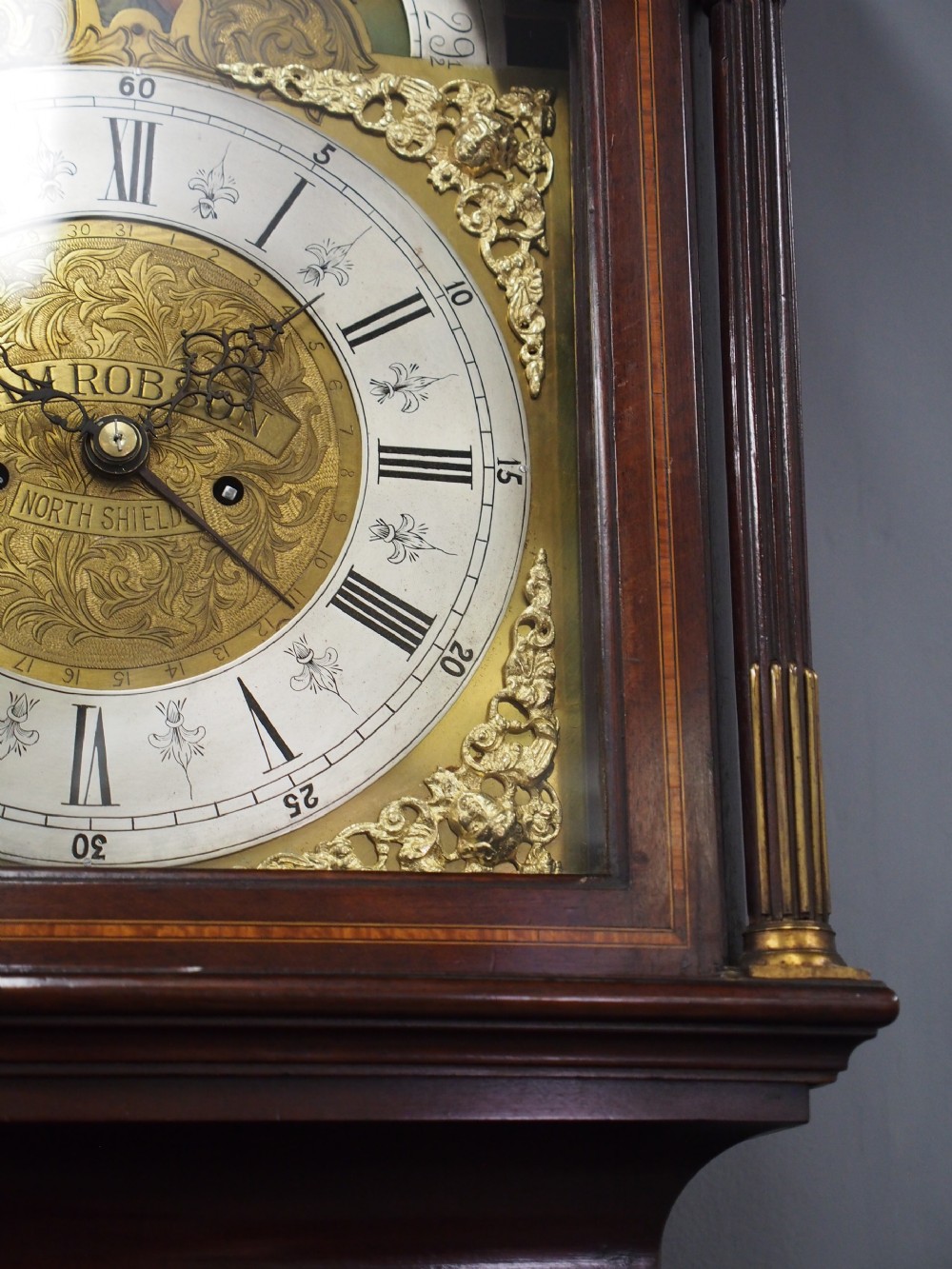 A tall Victorian mahogany longcase clock featuring a swan-neck pediment with fretwork, marquetry inlay, and a brass dial face. View III