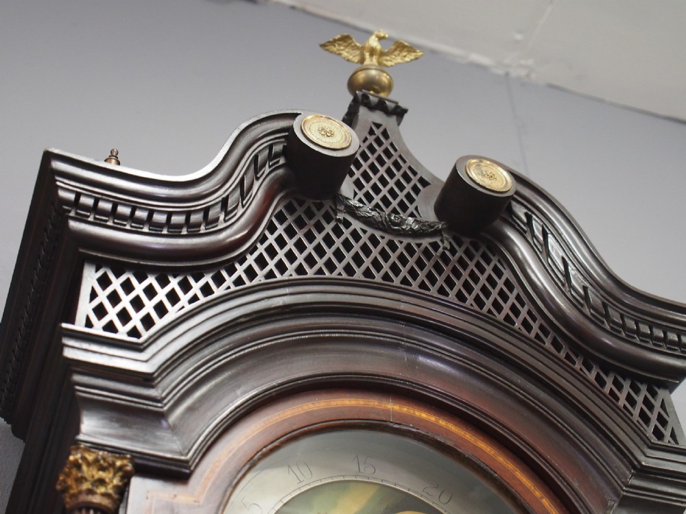A tall Victorian mahogany longcase clock featuring a swan-neck pediment with fretwork, marquetry inlay, and a brass dial face. View VII
