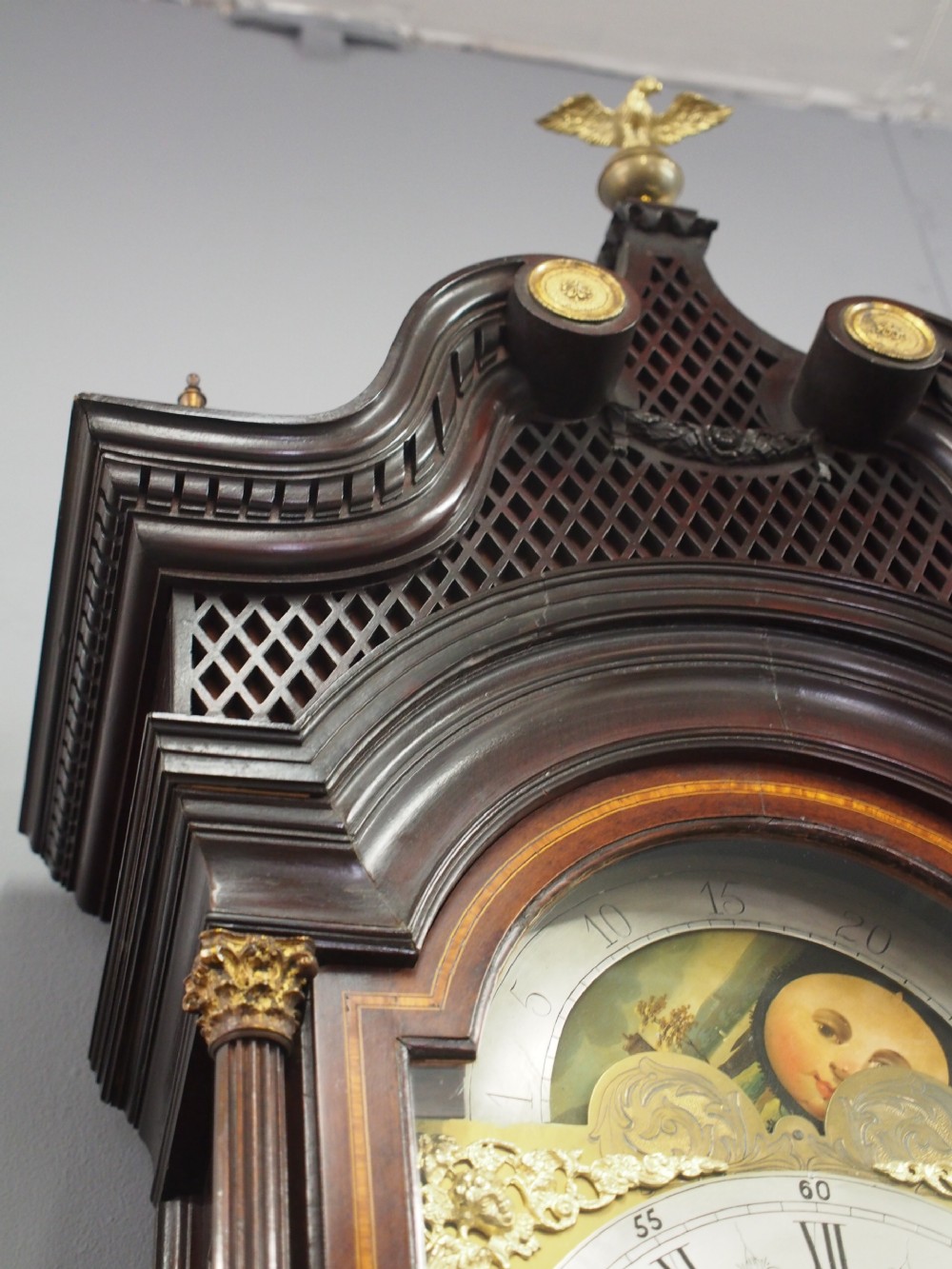 A tall Victorian mahogany longcase clock featuring a swan-neck pediment with fretwork, marquetry inlay, and a brass dial face. View VIII