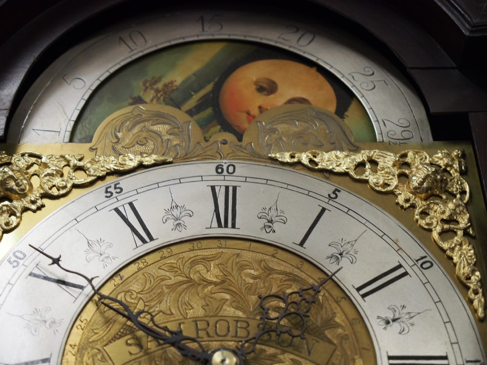 A tall Victorian mahogany longcase clock featuring a swan-neck pediment with fretwork, marquetry inlay, and a brass dial face. View XIV