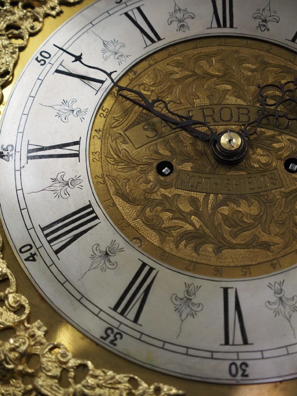 A tall Victorian mahogany longcase clock featuring a swan-neck pediment with fretwork, marquetry inlay, and a brass dial face. View XV