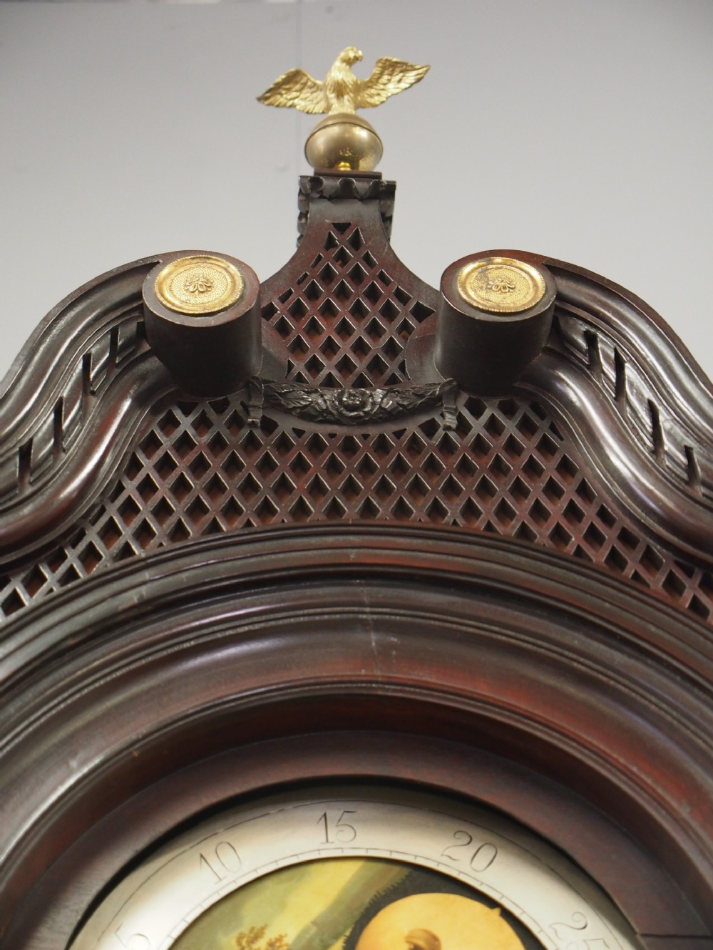 A tall Victorian mahogany longcase clock featuring a swan-neck pediment with fretwork, marquetry inlay, and a brass dial face. View XVII