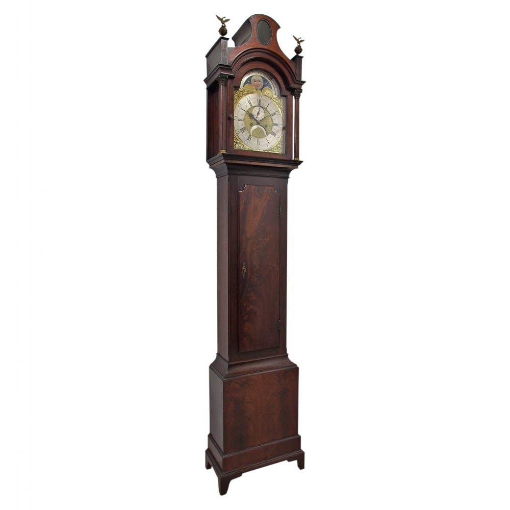 An antique George III mahogany longcase clock featuring a swan-neck pediment, brass dial with moonphase display, and dark timber trunk.