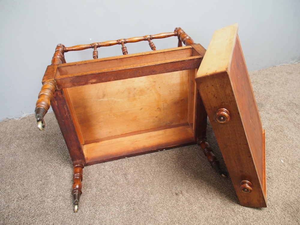 A George IV mahogany Canterbury featuring four slatted compartments with turned spindles, a single base drawer with turned wooden knobs, and turned legs ending in brass castors. View VIII