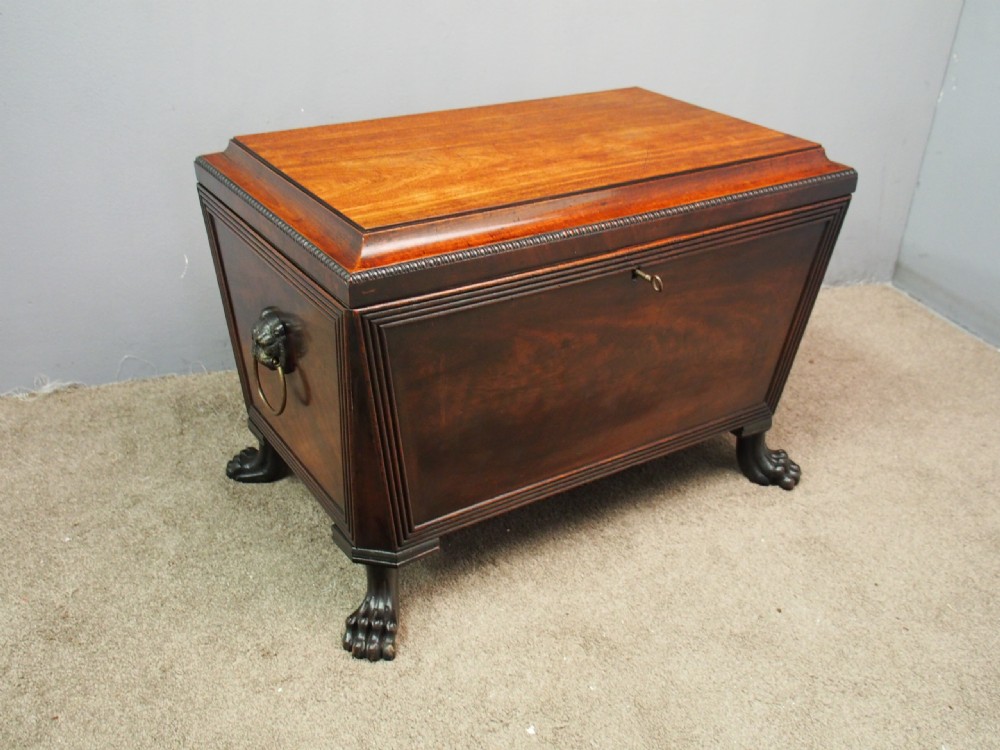 A Scottish Regency mahogany sarcophagus-shaped wine cooler featuring carved claw feet, gadrooned moulding, and side brass lion-mask drop ring handles. View III