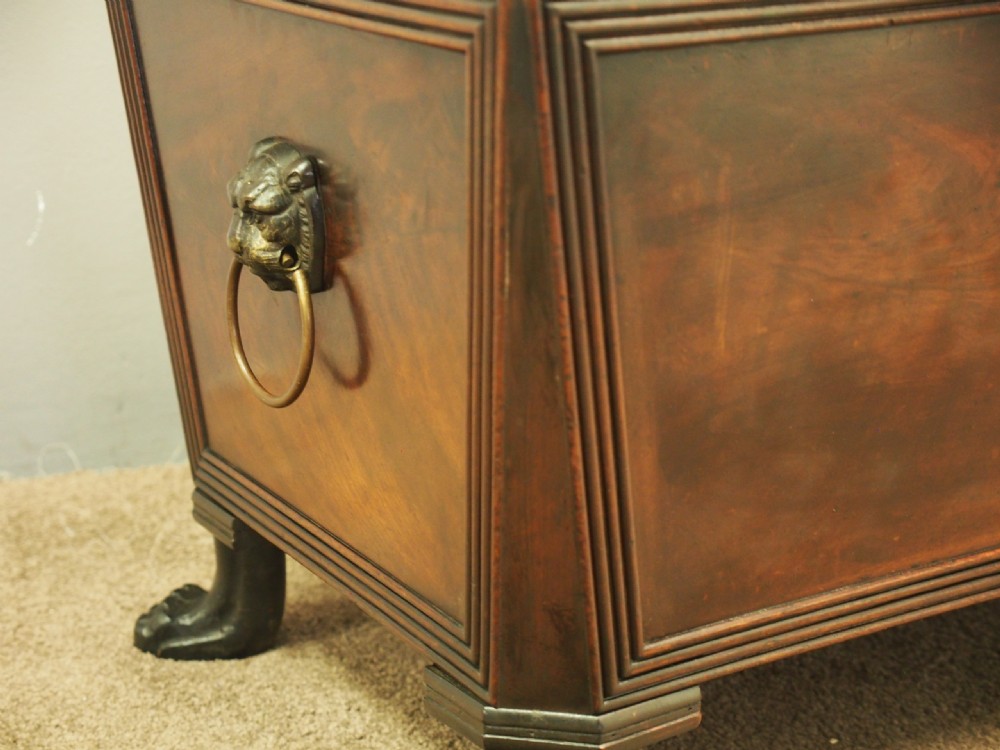 A Scottish Regency mahogany sarcophagus-shaped wine cooler featuring carved claw feet, gadrooned moulding, and side brass lion-mask drop ring handles. View IV