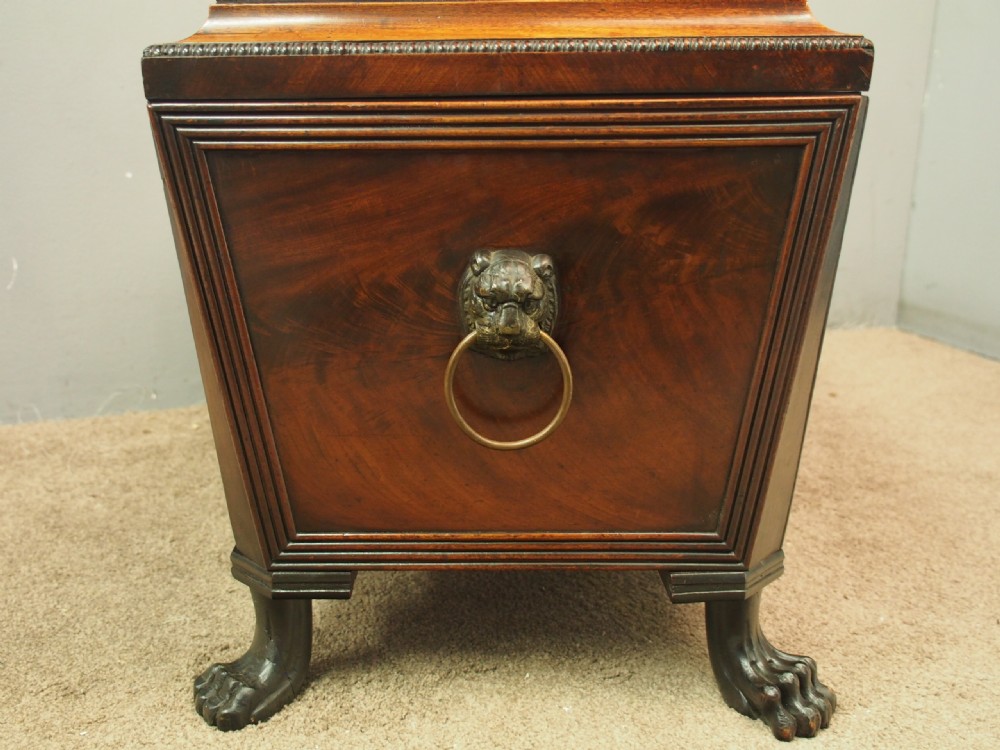 A Scottish Regency mahogany sarcophagus-shaped wine cooler featuring carved claw feet, gadrooned moulding, and side brass lion-mask drop ring handles. View VII