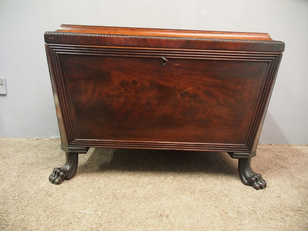 A Scottish Regency mahogany sarcophagus-shaped wine cooler featuring carved claw feet, gadrooned moulding, and side brass lion-mask drop ring handles. View XII