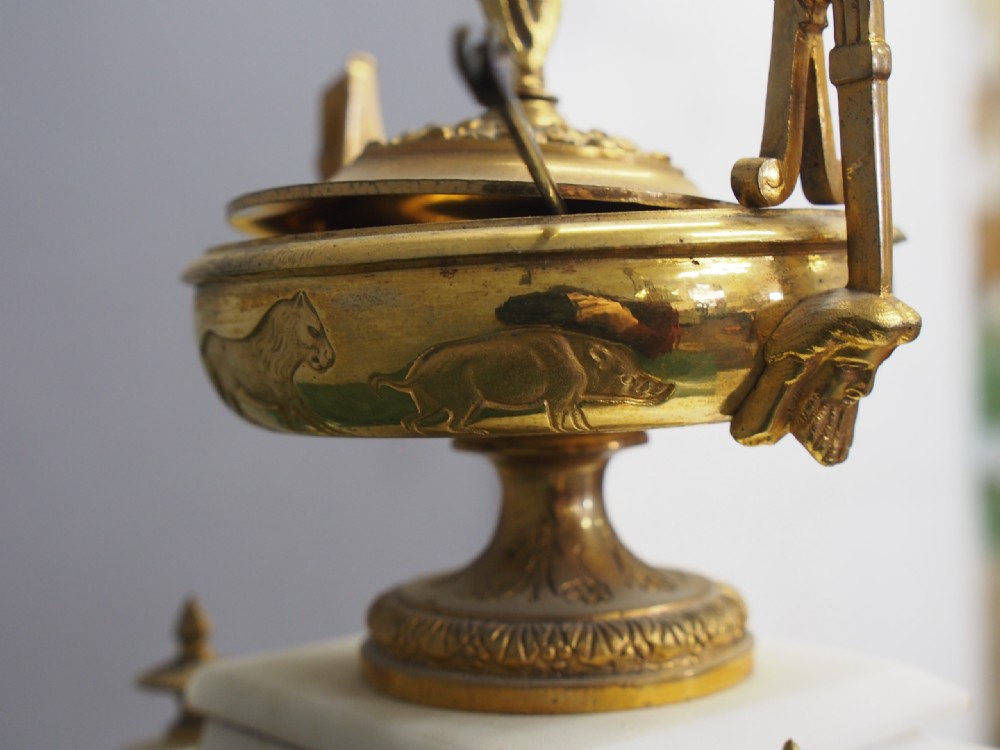 A white marble mantel clock featuring gilt bronze mounts, winged griffin corner supports, and a classical urn finial topped with a standing figure. View XIII