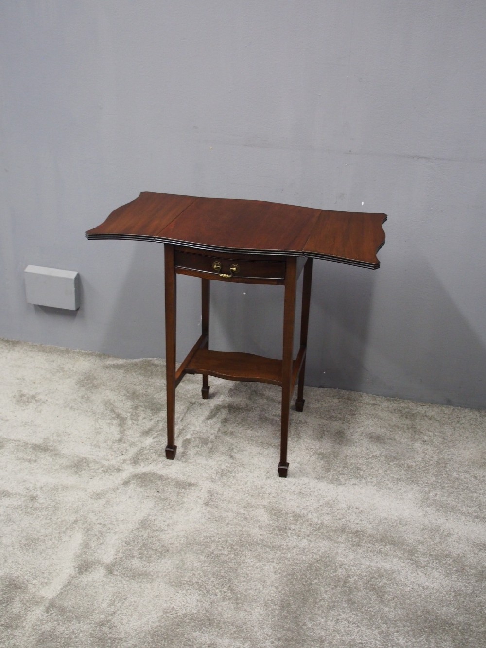 A Georgian style dark mahogany Pembroke table featuring two hinged drop leaves, a single frieze drawer with a brass pull handle, a lower undertier, and four straight legs. View III