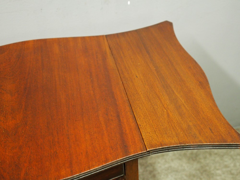A Georgian style dark mahogany Pembroke table featuring two hinged drop leaves, a single frieze drawer with a brass pull handle, a lower undertier, and four straight legs. View VI