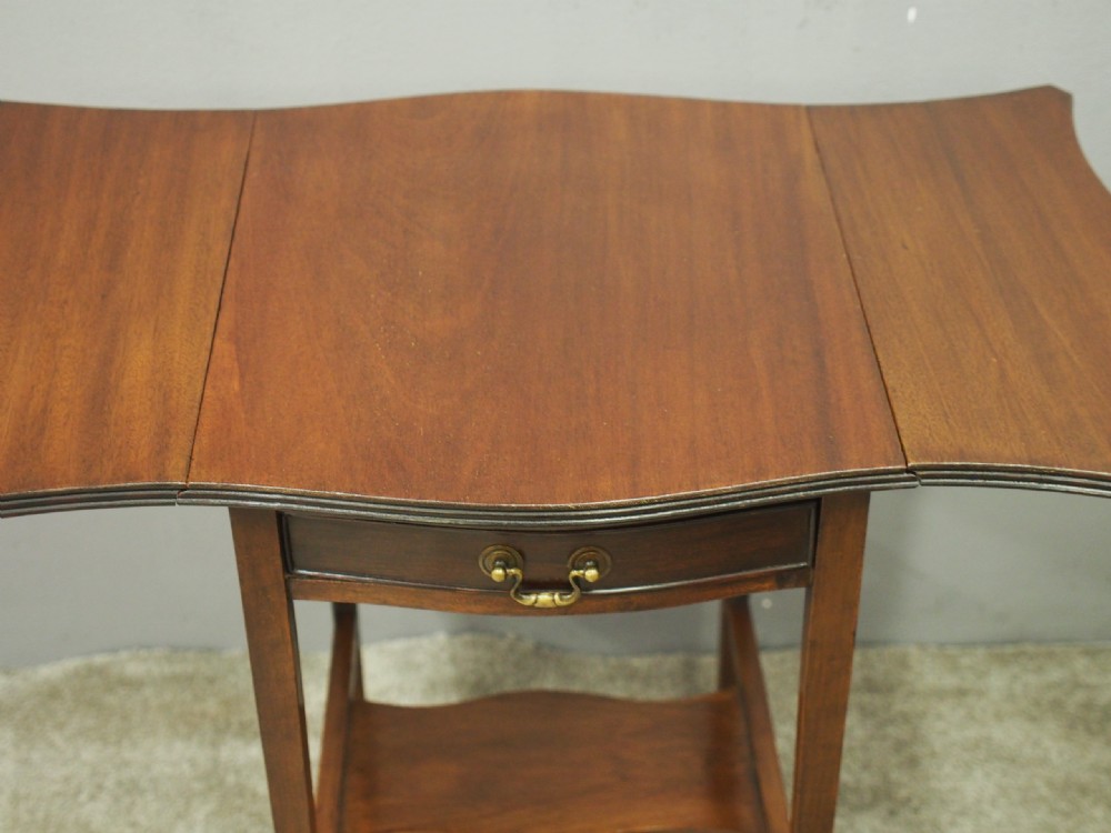 A Georgian style dark mahogany Pembroke table featuring two hinged drop leaves, a single frieze drawer with a brass pull handle, a lower undertier, and four straight legs. View VII