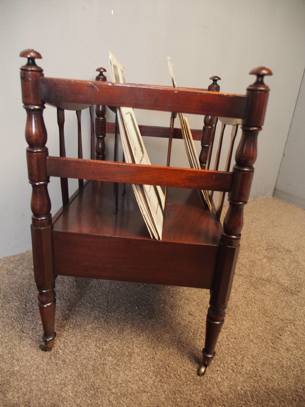 A George IV mahogany bowed canterbury featuring four open compartments, turned corner posts with finials, a lower drawer, and turned legs on brass castors. View VIII