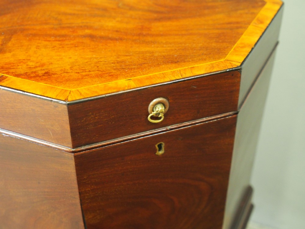 An eighteenth century octagonal mahogany wine cooler featuring brass drop handles, geometric edge inlay, and tapered legs. View V