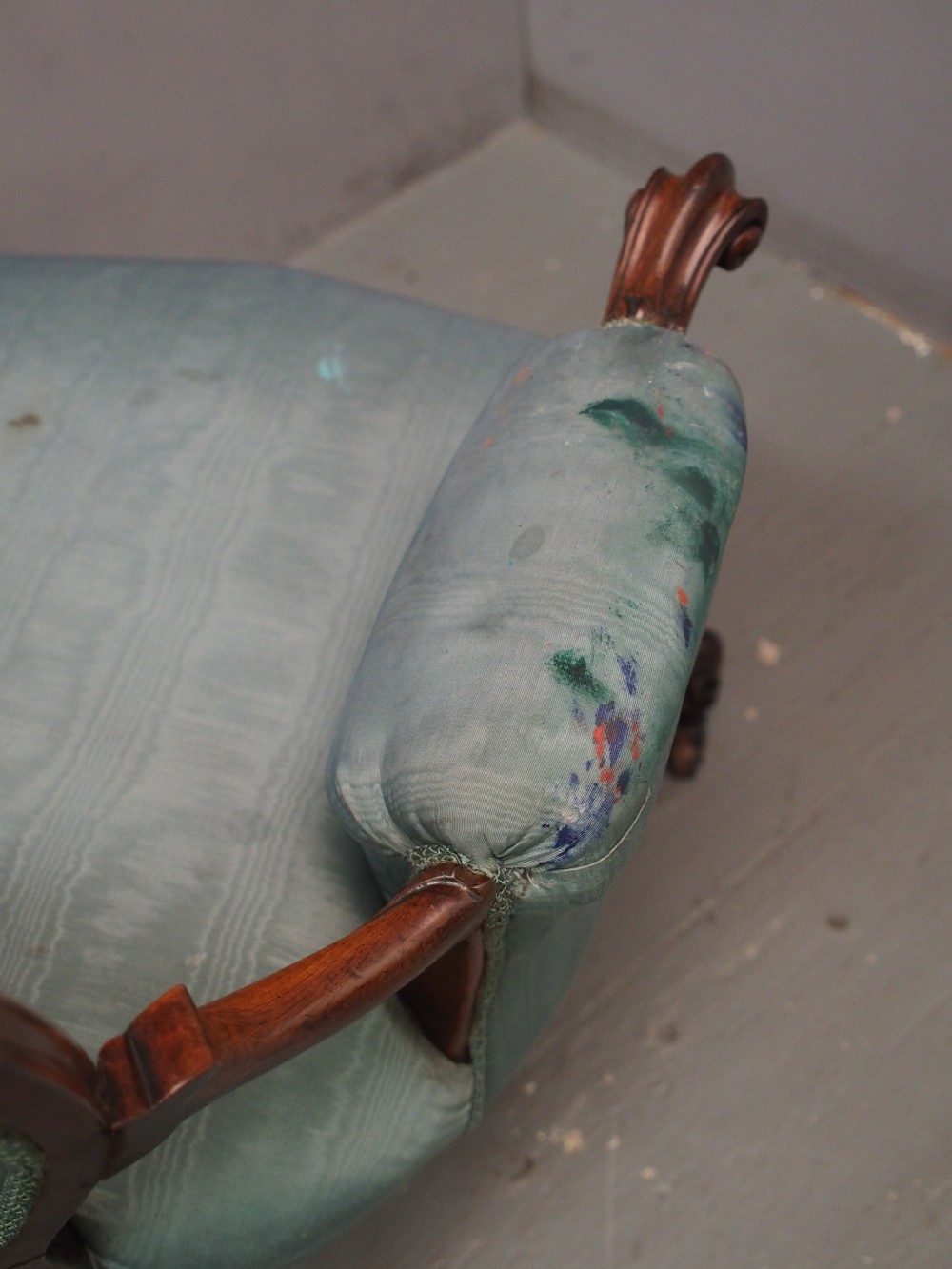 A Victorian carved walnut armchair featuring light blue button-tufted backrest upholstery, padded armrests, cabriole front legs, and metal castors. View XI