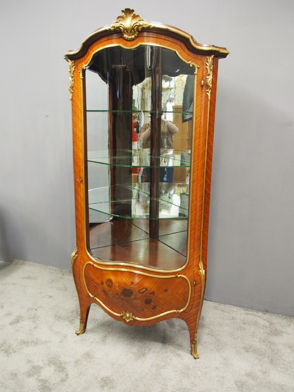 A Victorian corner vitrine in kingwood featuring curved glass doors, floral marquetry on the lower panel, and ornate brass ormolu mounts. View IV