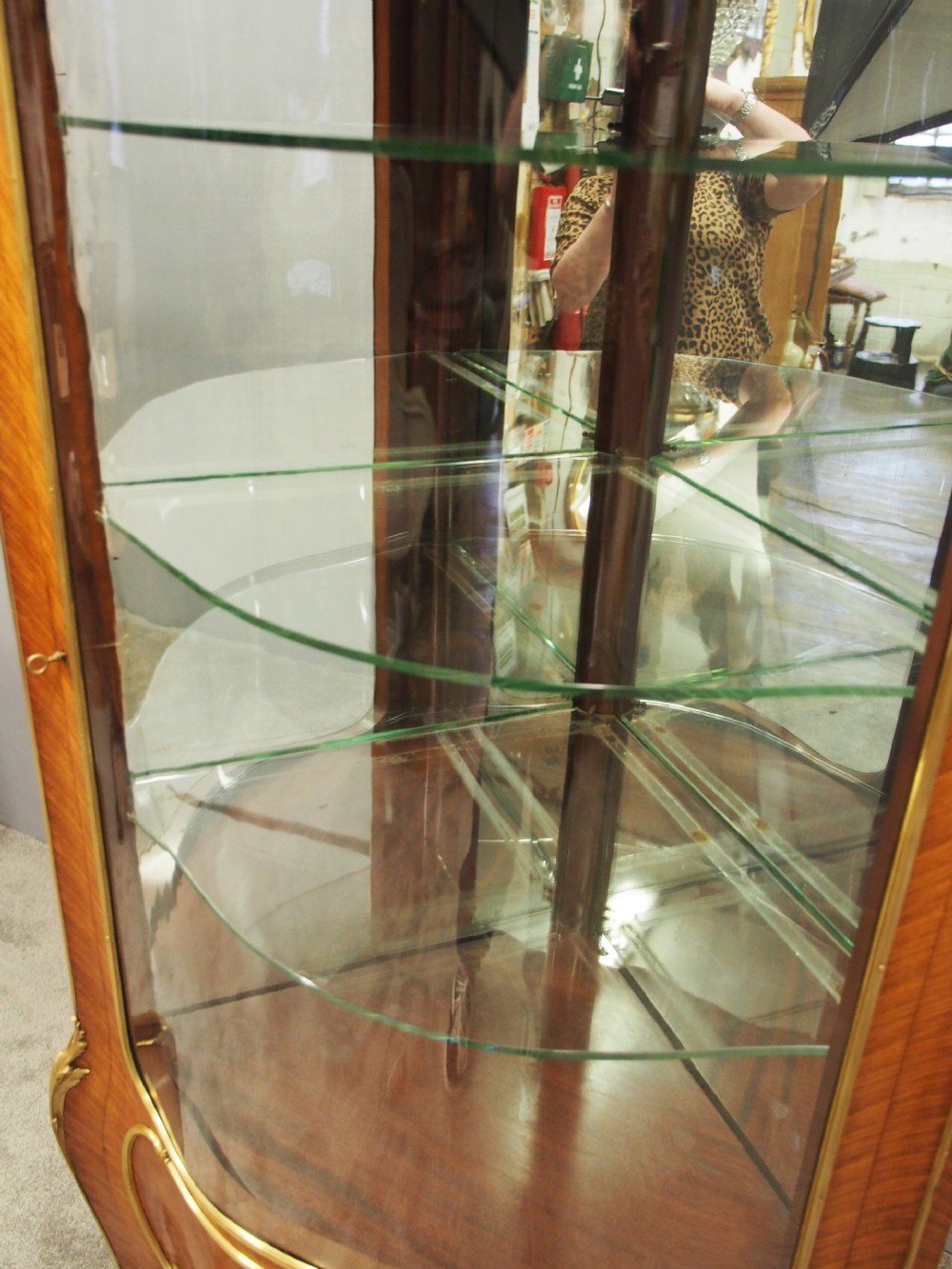 A Victorian corner vitrine in kingwood featuring curved glass doors, floral marquetry on the lower panel, and ornate brass ormolu mounts. View VIII