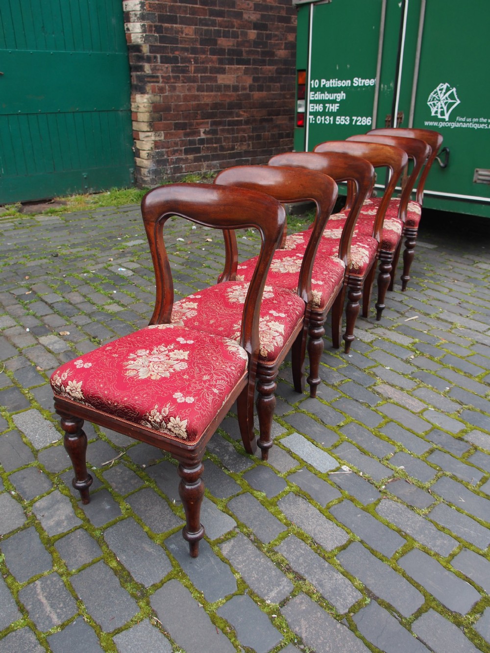 A set of six Victorian mahogany balloon back dining chairs with red patterned upholstered seats and turned front legs. View III