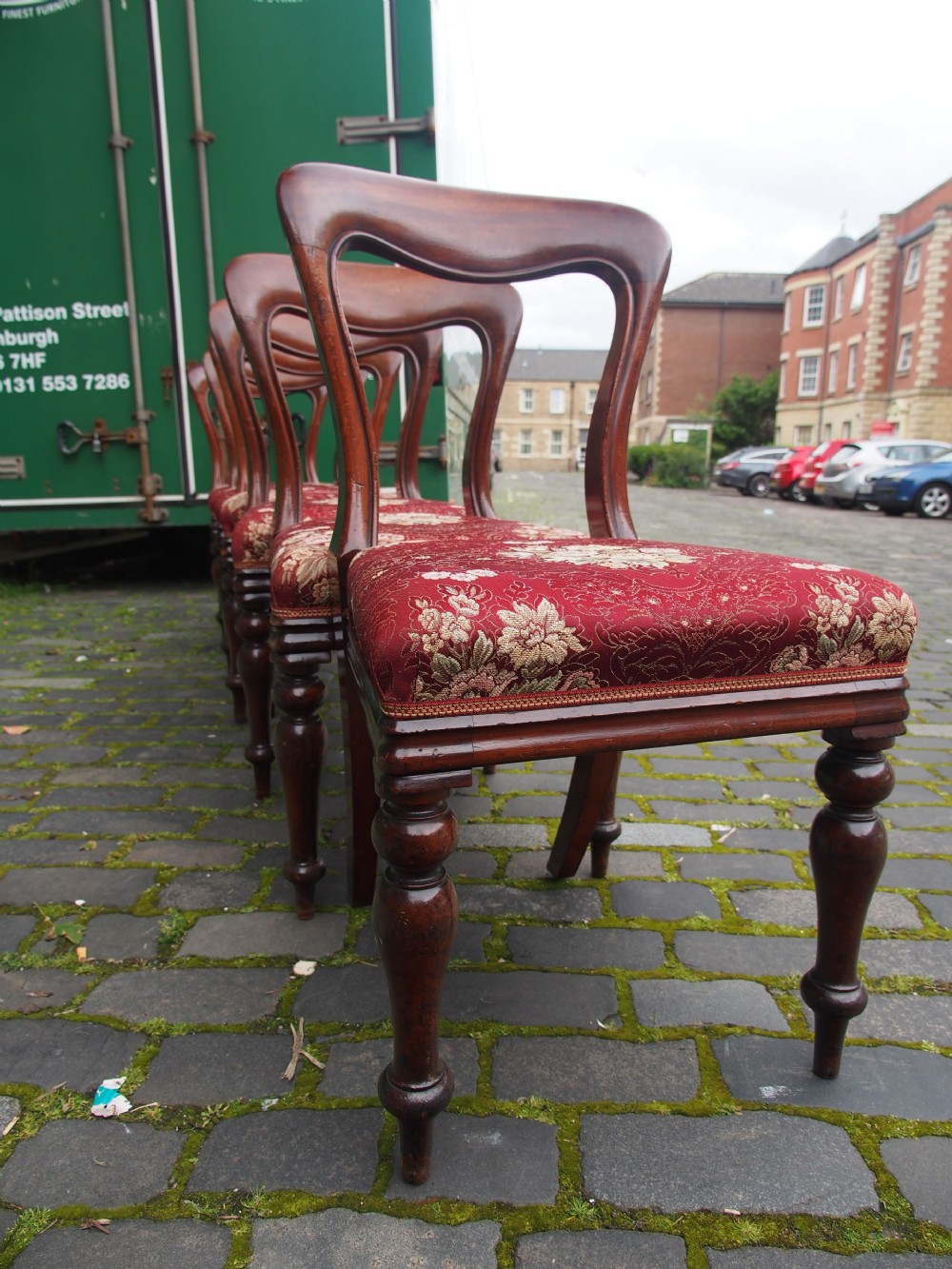 A set of six Victorian mahogany balloon back dining chairs with red patterned upholstered seats and turned front legs. View V