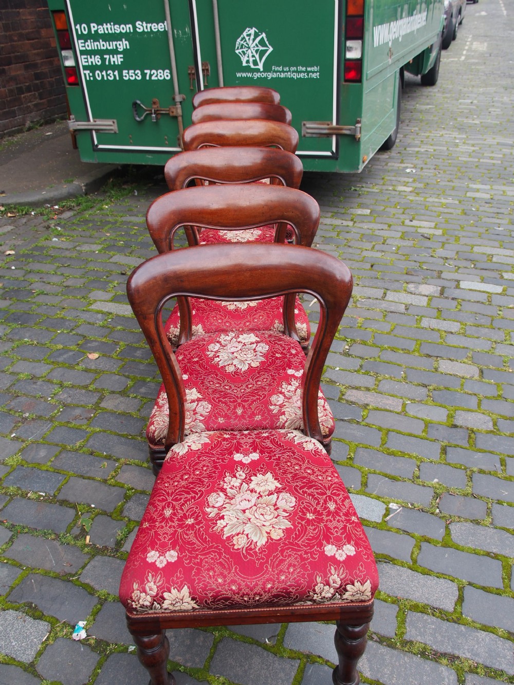 A set of six Victorian mahogany balloon back dining chairs with red patterned upholstered seats and turned front legs. View VI